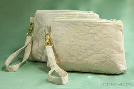 Essential Wristlet - two sizes, in ivory brocade decorator weight fabric. Top zip, removable wrist strap, inside has small slip pocket.